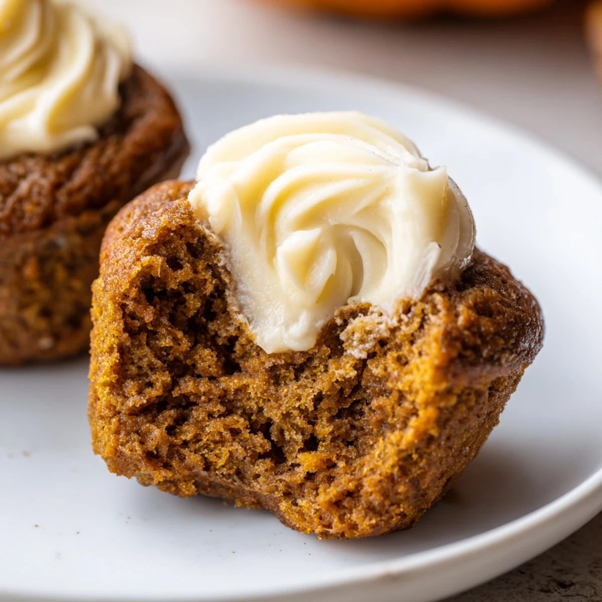 Moist gingerbread pumpkin muffin thumbprints topped with creamy filling for autumn delight.  