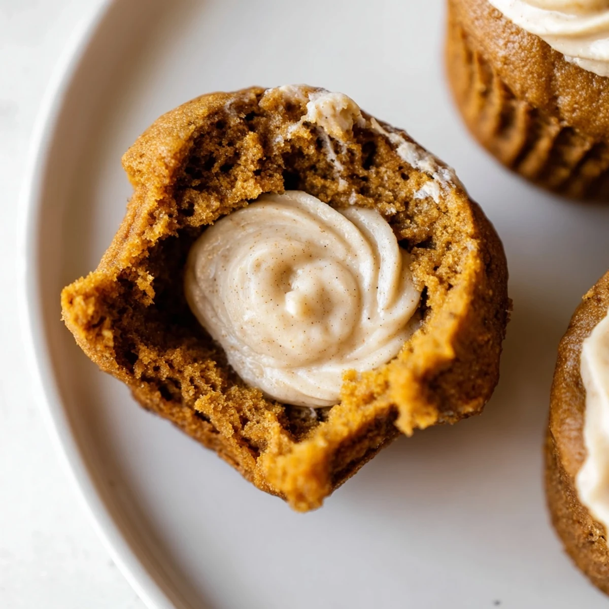 Delicious gingerbread pumpkin muffin thumbprints, drizzled with creamy filling for cozy gatherings.