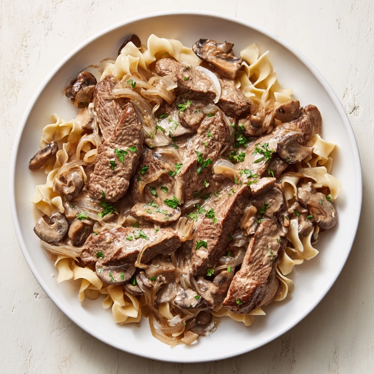 Creamy Mushroom Beef Stroganoff: A comforting bowl of tender beef and creamy mushroom sauce atop egg noodles.