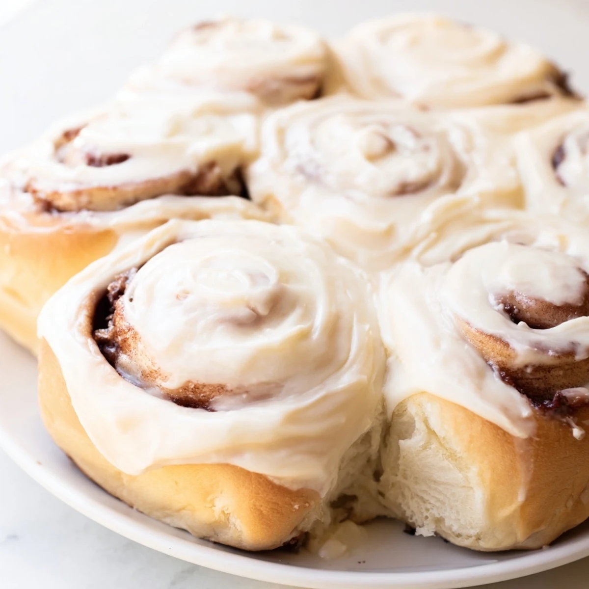 Warm and gooey TikTok Heavy Cream Cinnamon Rolls, fresh from the oven, glistening with delicious icing.