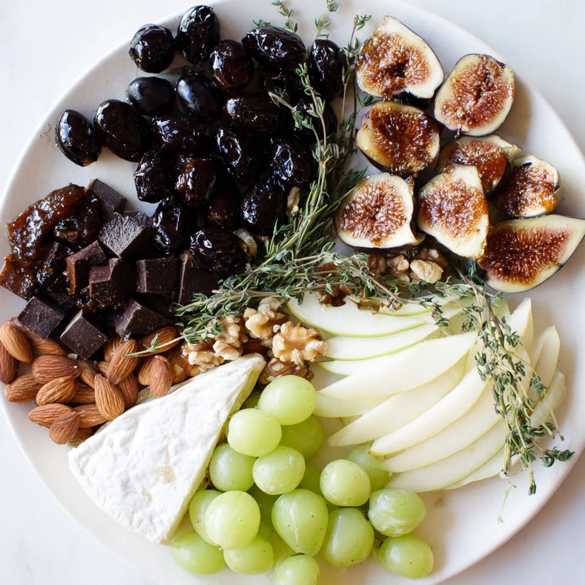 Artfully arranged Winter Solstice Board, offering savory olives and sweet figs alongside creamy Brie.