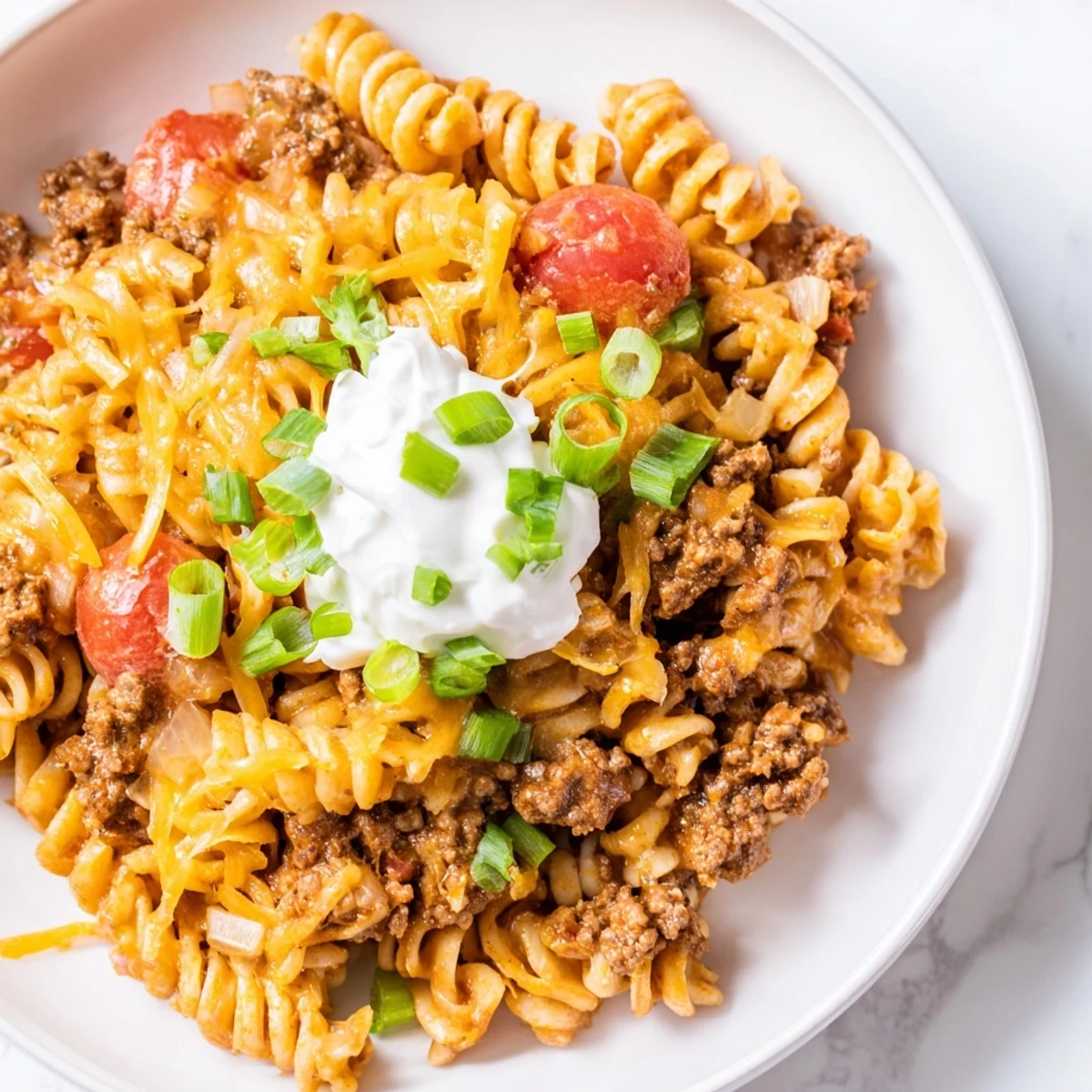 One-Pot Taco Pasta, a bubbling skillet of cheesy pasta and savory ground beef, ready to eat.