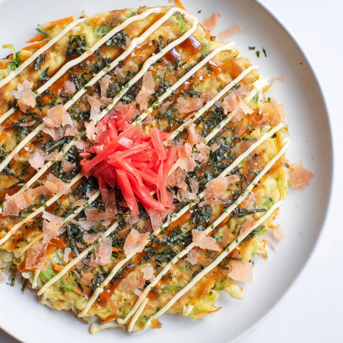 Steaming hot Japanese Okonomiyaki pancakes topped with savory sauce, ready to be devoured fresh.