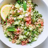 A close-up of a delicious Tabbouleh Grain Bowl, showcasing fresh herbs and a drizzle of olive oil.