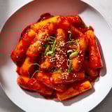 A close-up of piping hot Korean Tteokbokki, offering a blend of savory and delightful spicy flavors in every bite.