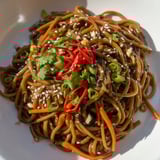 Close-up of glossy Asian Garlic Noodle Bowl, showcasing the rich garlic-butter sauce coating the noodles.