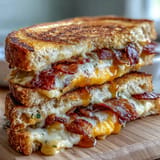 Juicy bacon grilled cheese sandwich generously drizzled with sweet spicy hot honey.