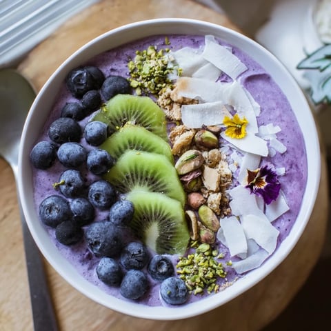 A vibrant smoothie bowl, featuring purple yam and fresh fruits, ready to enjoy.  
