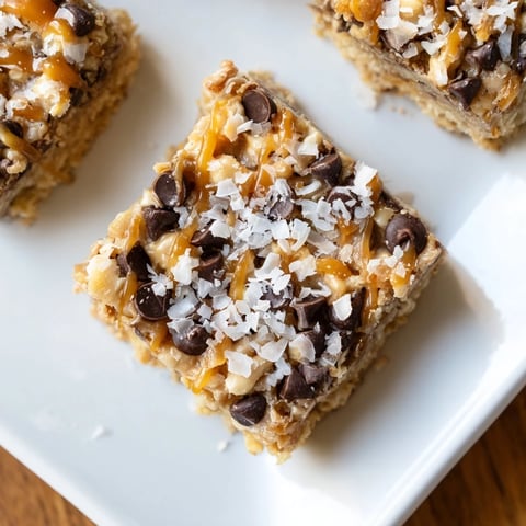 Golden brown 7-Layer Magic Bars with drizzles of salted caramel shining on top, ready to serve.