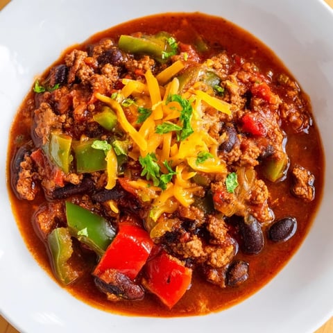 Steaming bowl of quick chili with canned beans, topped with fresh cilantro and a dollop of sour cream.