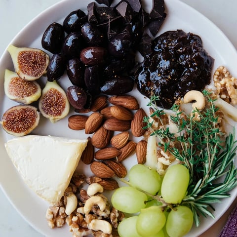 The Winter Solstice Board: a beautifully arranged cheese board with olives, figs, and Brie creating visual delight.