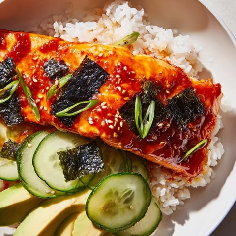 Emily Mariko-Inspired Sticky Orange Gochujang Salmon Bowl with glistening glaze and fresh cucumber.