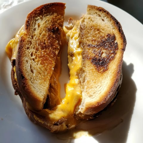 Melted cheddar oozes from this honey chipotle butter grilled cheese sandwich on golden sourdough.