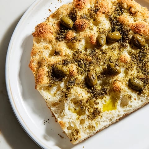 Golden-brown Zaatar Olive Focaccia, a warm, fragrant artisan bread with salty Kalamata olives.