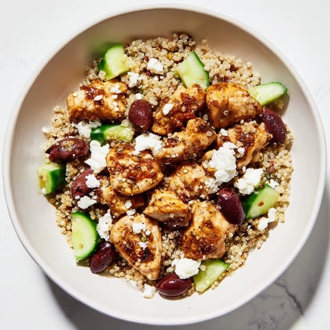 Colorful Mediterranean Chicken Bowl featuring golden grilled chicken, creamy feta, Kalamata olives, cucumbers, tomatoes, and fluffy quinoa, all tossed with a zesty lemon-oregano dressing.