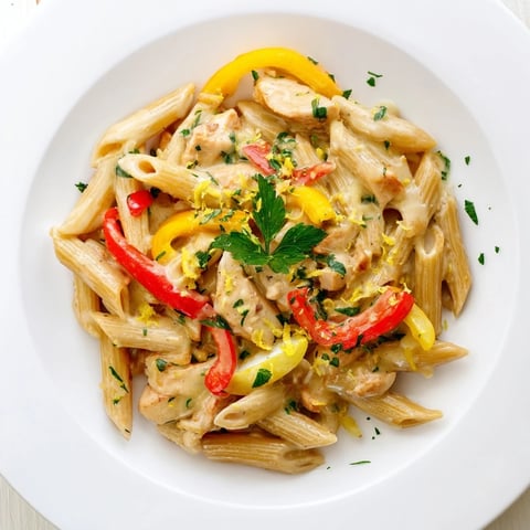 Creamy Cajun Chicken Pasta Lite features golden chicken strips and whole wheat penne coated in a light, spicy cream sauce with vibrant bell peppers and onions.  