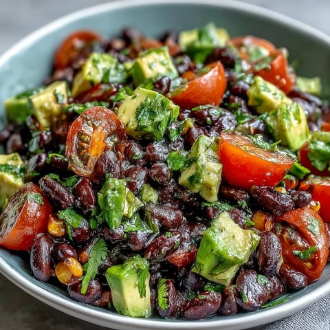 A vibrant Black Bean and Veggie Bowl topped with creamy avocado and fresh cilantro, ready to serve.