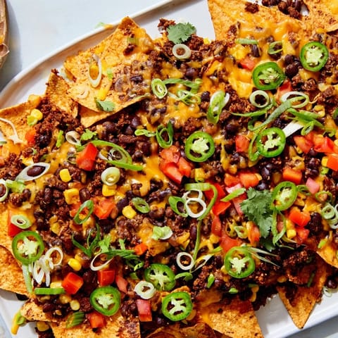 Golden, melted cheese blankets sheet-pan nachos with beans, a colorful and easy vegetarian dinner idea.