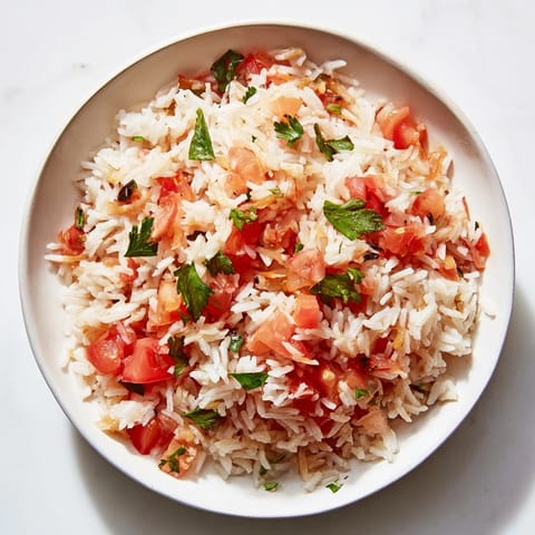A close-up of a delightful Tomato-Rice Skillet Dinner, featuring fluffy rice and bright red tomatoes.