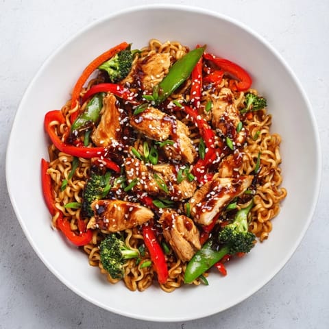 This vibrant photo shows a sheet-pan crispy ramen meal with tender chicken and colorful veggies.