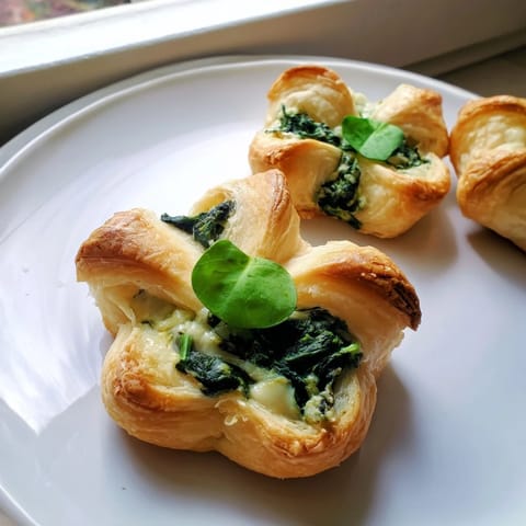 Close-up of baked Lucky Clover St. Patrick's Day Bites, showcasing golden crusts and basil garnish.