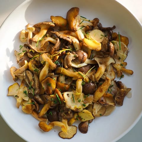 A vibrant close-up of Enchanted Forest Mushrooms, showcasing tender mushrooms garnished with herbs and zest.