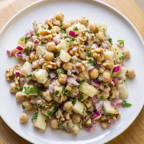 A refreshing bowl of Fall Harvest Apple and Chickpea Salad with crunchy walnuts and red onion, perfect for lunch.