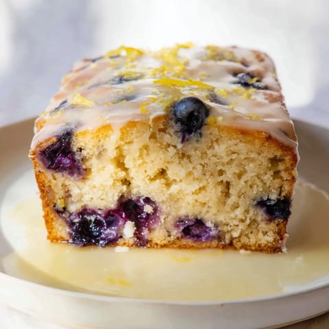 Fluffy Lemon Blueberry Yogurt Loaf, studded with juicy blueberries, ready to slice and enjoy.