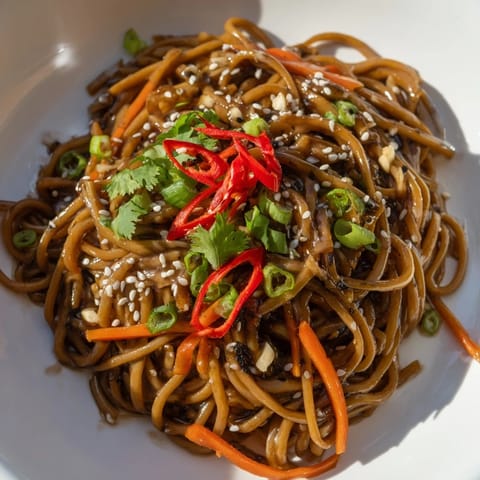 Close-up of glossy Asian Garlic Noodle Bowl, showcasing the rich garlic-butter sauce coating the noodles.