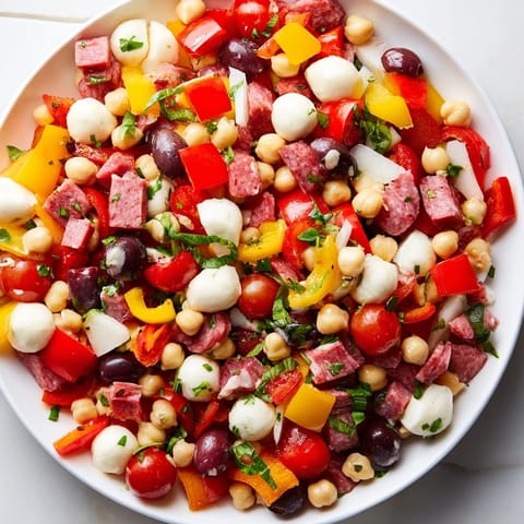 A colorful bowl of Crunchy Antipasto Chopped Salad served as a light lunch, garnished with fresh basil and parsley.