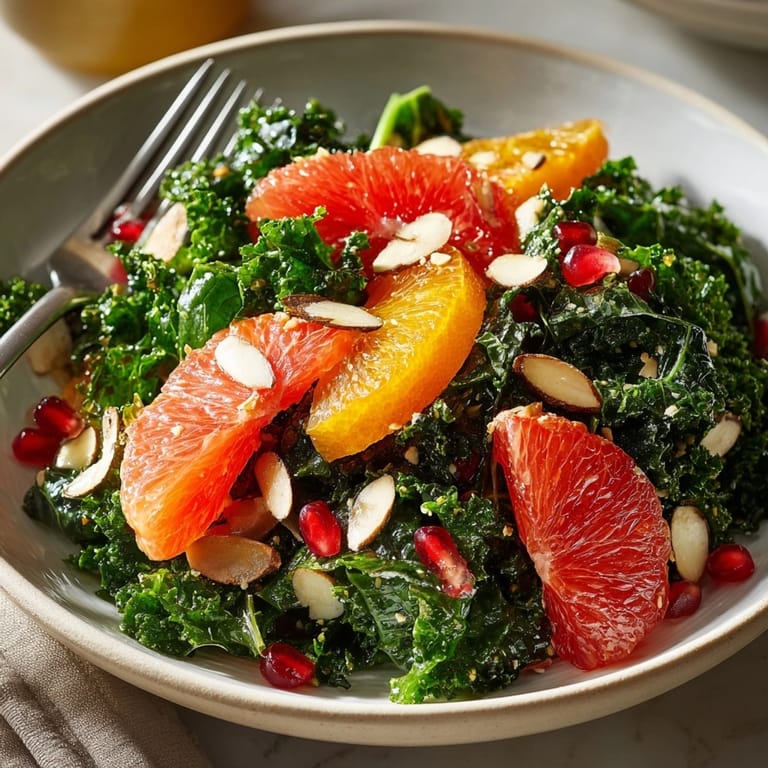 Tossed Winter Citrus Kale Salad, showcasing ruby pomegranate seeds alongside juicy orange and grapefruit slices.