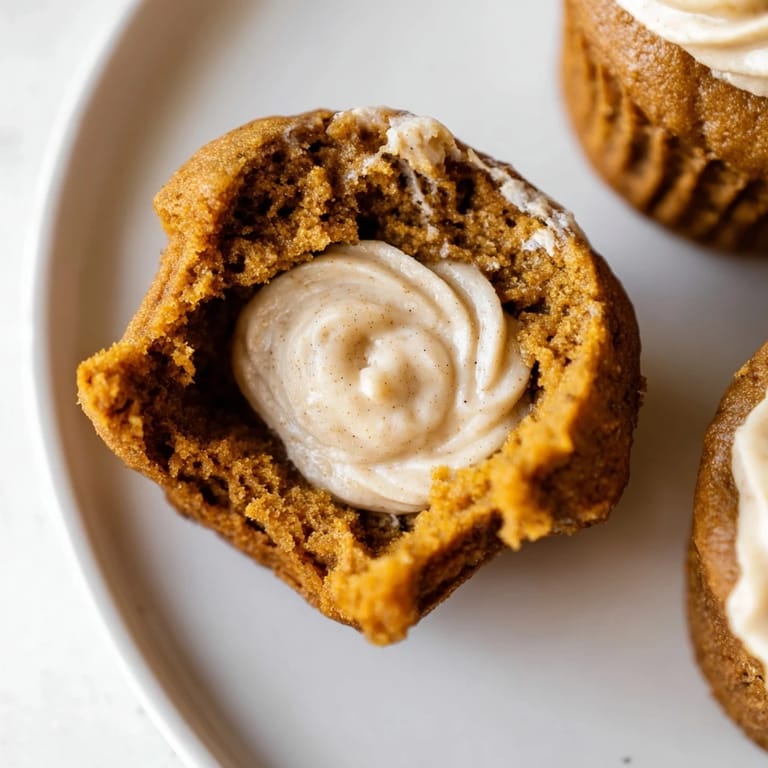 Delicious gingerbread pumpkin muffin thumbprints, drizzled with creamy filling for cozy gatherings.