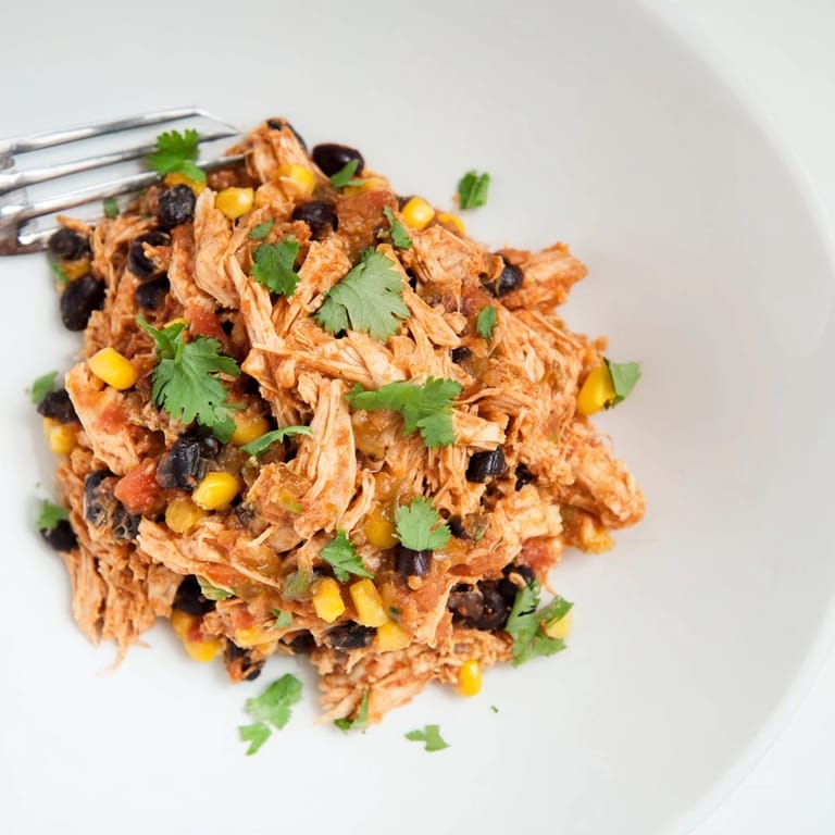 Close-up shot shows tender Slow Cooker Salsa Chicken, ideal for a quick and easy weeknight dinner.