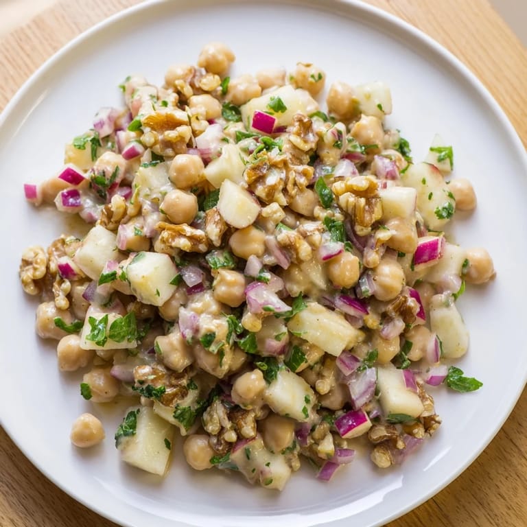 A refreshing bowl of Fall Harvest Apple and Chickpea Salad with crunchy walnuts and red onion, perfect for lunch.