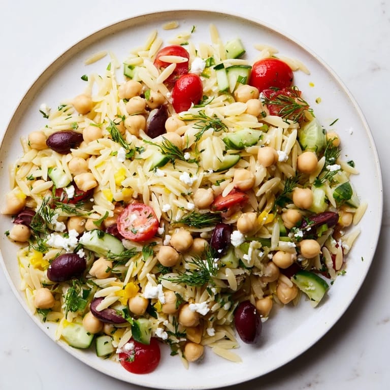 Cool, refreshing Greek Lemon-Orzo Bean Salad served in a light-filled setting, perfect for lunch.