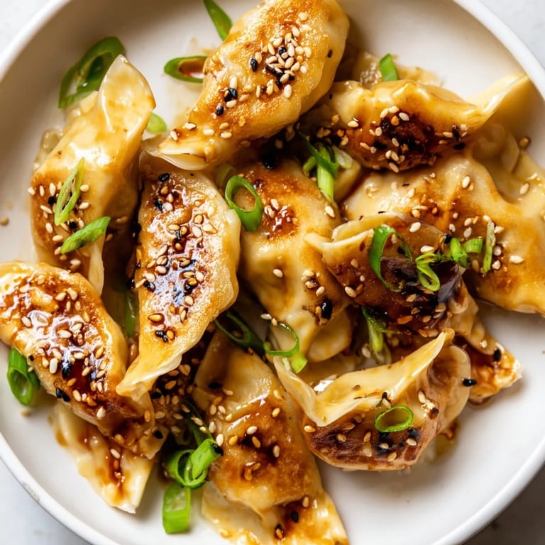 Close-up of perfectly cooked air fryer frozen dumplings with a beautiful, glossy sesame glaze finish.