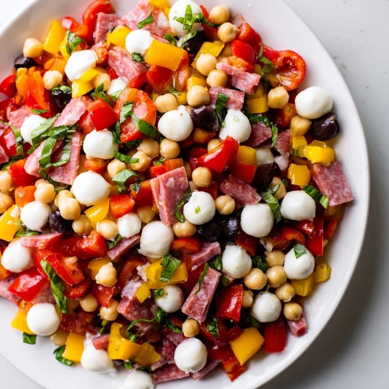 Close-up of Crunchy Antipasto Chopped Salad featuring chickpeas, olives, and pepperoncini tossed with a homemade Italian vinaigrette.